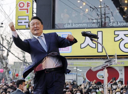 윤석열 대통령 당선인이 지난 11일 오후 경북 포항시 북구 죽도시장을 방문해 환영 나온 시민들에게 어퍼컷 세리머니로 인사하고 있다. <연합뉴스>
